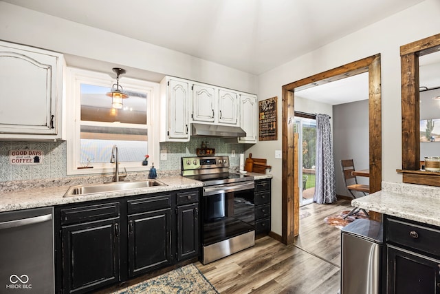 527 E 125 S, Williamsport, IN 47993 - kitchen featuring appliances with stainless steel finishes, dark cabinetry, under cabinet range hood, white cabinetry, and a sink