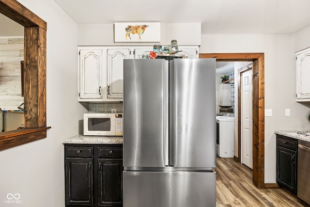 527 E 125 S, Williamsport, IN 47993 - kitchen with stainless steel appliances, white cabinets, light wood finished floors, dark cabinets, and washing machine and dryer