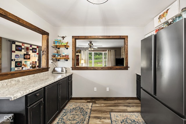 527 E 125 S, Williamsport, IN 47993 - kitchen with freestanding refrigerator, dark cabinetry, dark wood finished floors, ceiling fan, and baseboards