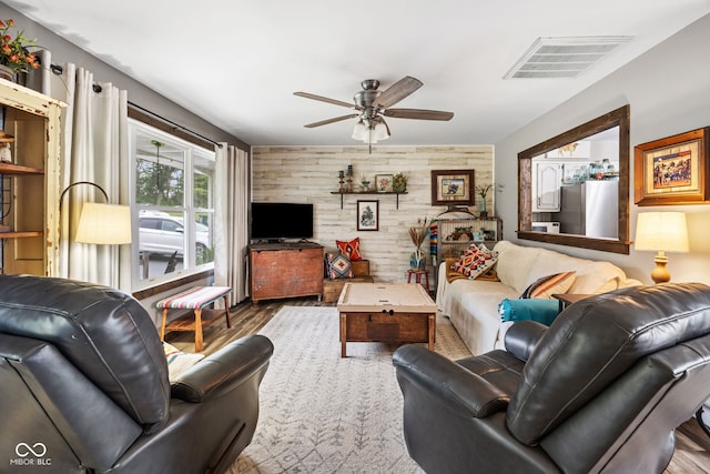 527 E 125 S, Williamsport, IN 47993 - living room with wooden walls, a ceiling fan, wood finished floors, and an accent wall
