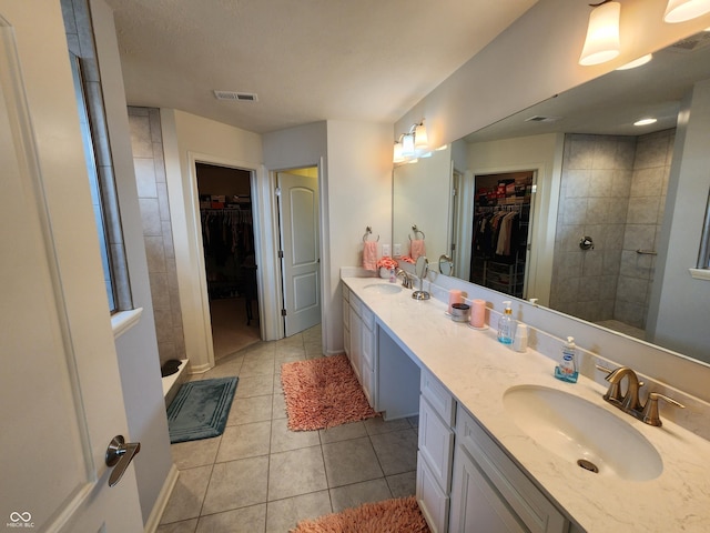 6731 Keepsake Dr, Whitestown, IN 46075 - bathroom featuring a spacious closet, double vanity, tile patterned floors, and tiled shower
