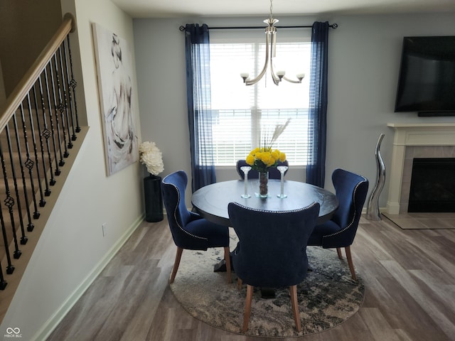 6731 Keepsake Dr, Whitestown, IN 46075 - dining room featuring wood finished floors, a chandelier, baseboards, and stairs
