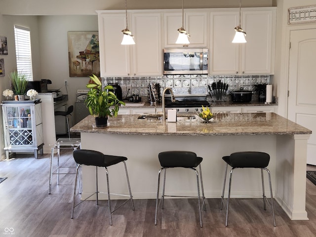 6731 Keepsake Dr, Whitestown, IN 46075 - kitchen with stainless steel microwave, tasteful backsplash, a sink, and light wood-style floors