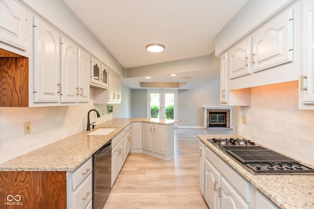 8955 Stonegate Rd Unit A, Indianapolis, IN 46227 - kitchen with dishwasher, stovetop with downdraft, a peninsula, light wood-style flooring, and light stone countertops
