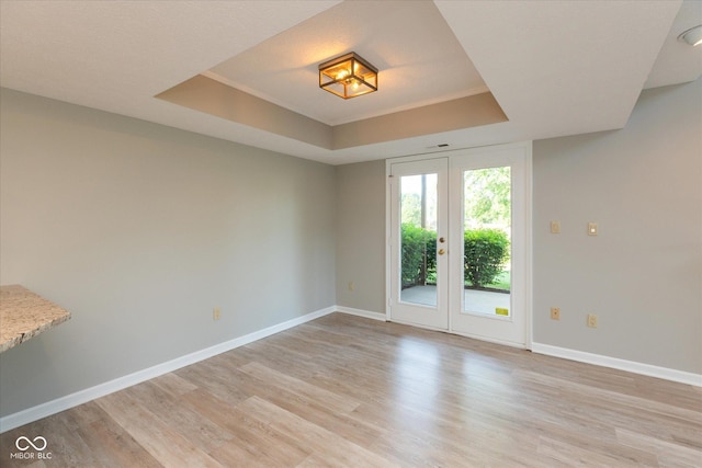 8955 Stonegate Rd Unit A, Indianapolis, IN 46227 - spare room featuring a tray ceiling, light wood-type flooring, and french doors
