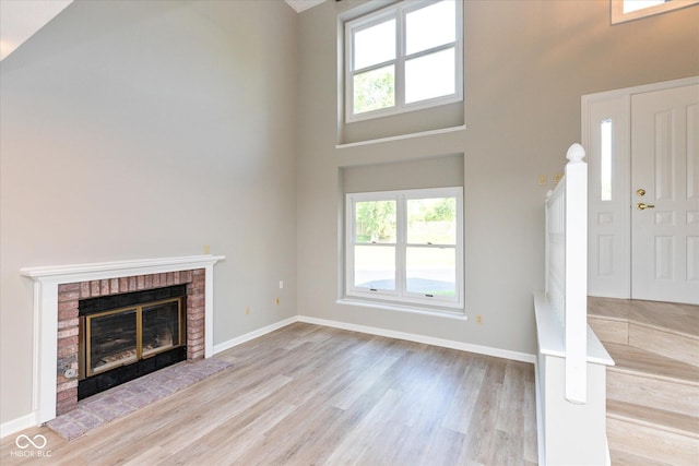8955 Stonegate Rd Unit A, Indianapolis, IN 46227 - unfurnished living room with healthy amount of natural light, wood finished floors, a fireplace, and a high ceiling