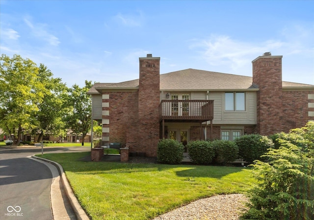 8955 Stonegate Rd Unit A, Indianapolis, IN 46227 - rear view of house featuring a lawn, brick siding, a balcony, and a chimney