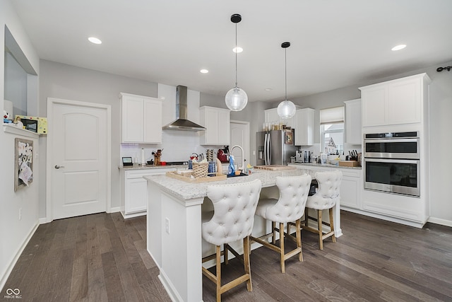15598 Memorial Way, Fishers, IN 46037 - kitchen with wall chimney range hood, stainless steel appliances, a kitchen island with sink, dark wood-type flooring, and a kitchen bar