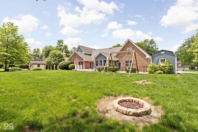 5695 N Red Oak Dr, Greenfield, IN 46140 - view of front of house with brick siding, an outdoor fire pit, a front yard, and a patio