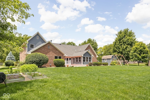 5695 N Red Oak Dr, Greenfield, IN 46140 - back of property with a garden, brick siding, a yard, a playground, and a patio area