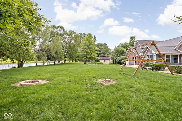 5695 N Red Oak Dr, Greenfield, IN 46140 - view of grassy yard featuring a water view, a playground, an outdoor fire pit, and a storage unit