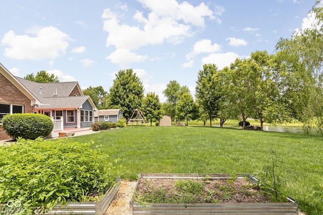5695 N Red Oak Dr, Greenfield, IN 46140 - view of green lawn featuring a vegetable garden and a shed