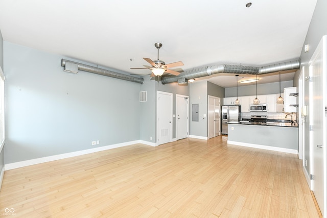721 E N St Unit 2C, Indianapolis, IN 46202 - unfurnished living room with a ceiling fan, electric panel, and light wood-style flooring