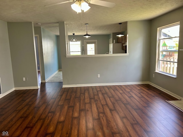 12307 Chiseled Stone Dr, Fishers, IN 46037 - empty room with dark wood-style floors, ceiling fan, a textured ceiling, healthy amount of natural light, and baseboards
