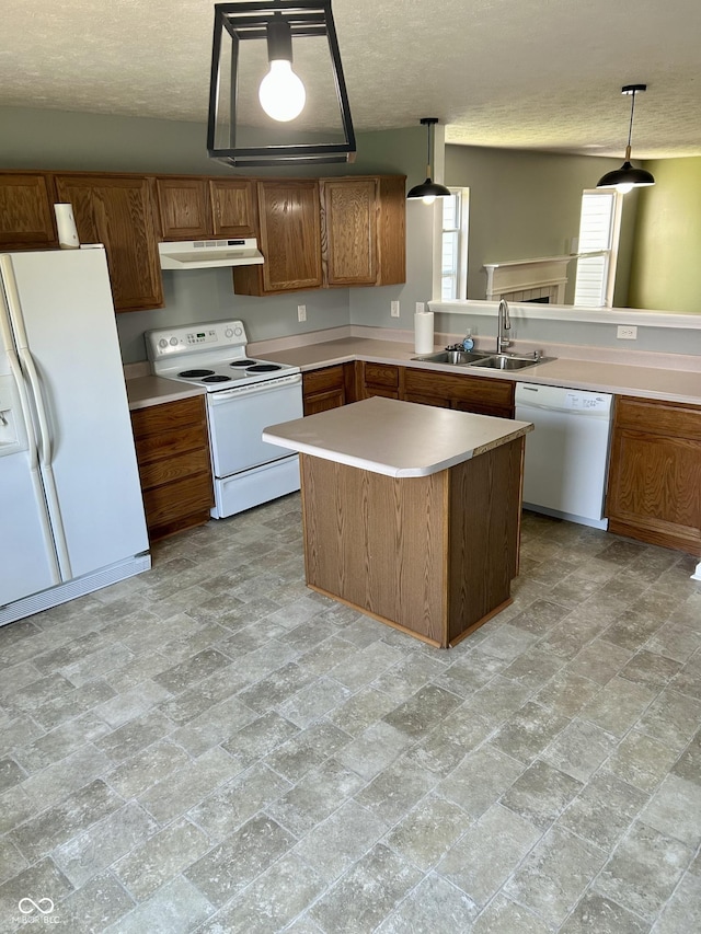 12307 Chiseled Stone Dr, Fishers, IN 46037 - kitchen featuring white appliances, under cabinet range hood, a sink, light countertops, and decorative light fixtures