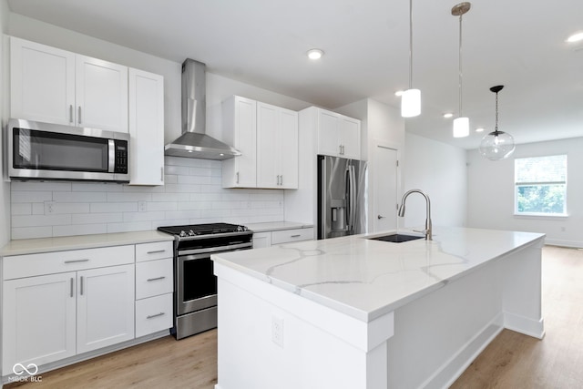 751 Switchyard Pl, Indianapolis, IN 46202 - kitchen featuring stainless steel appliances, wall chimney range hood, a sink, light wood-style floors, and tasteful backsplash