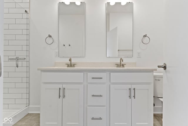 751 Switchyard Pl, Indianapolis, IN 46202 - bathroom featuring double vanity, tile patterned flooring, tiled shower, and baseboards