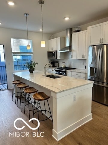 751 Switchyard Pl, Indianapolis, IN 46202 - kitchen with stainless steel appliances, wall chimney exhaust hood, a sink, wood finished floors, and recessed lighting
