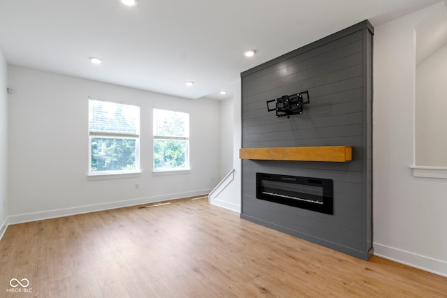 751 Switchyard Pl, Indianapolis, IN 46202 - unfurnished living room with light wood-style flooring, a fireplace, baseboards, and recessed lighting