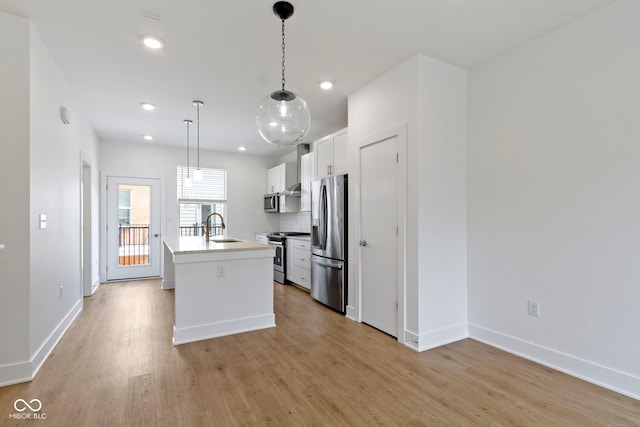 751 Switchyard Pl, Indianapolis, IN 46202 - kitchen with appliances with stainless steel finishes, a sink, light wood-style flooring, a kitchen island with sink, and baseboards