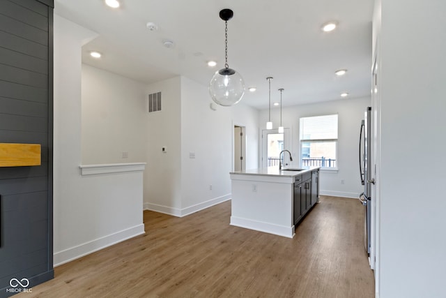 751 Switchyard Pl, Indianapolis, IN 46202 - kitchen with a sink, baseboards, wood finished floors, recessed lighting, and an island with sink