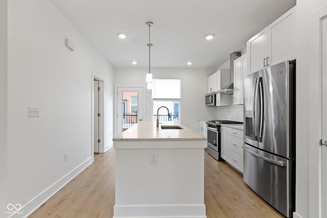 751 Switchyard Pl, Indianapolis, IN 46202 - kitchen with stainless steel appliances, a sink, white cabinets, a kitchen island with sink, and light wood-style flooring