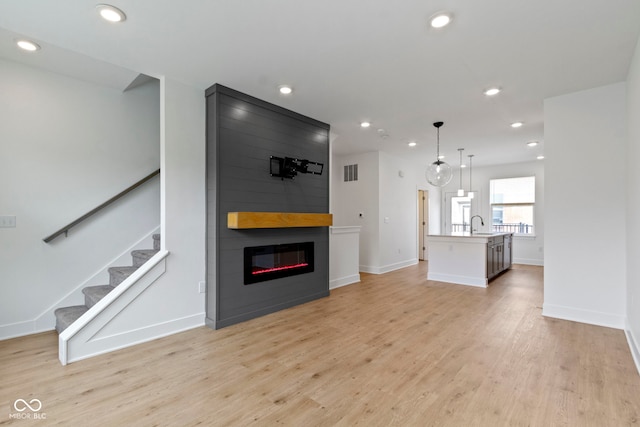 751 Switchyard Pl, Indianapolis, IN 46202 - unfurnished living room featuring a fireplace, stairway, recessed lighting, light wood-style flooring, and baseboards