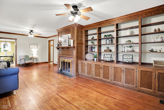 6644 Mcfarland Rd, Indianapolis, IN 46227 - living area with a ceiling fan, light wood finished floors, a brick fireplace, and crown molding