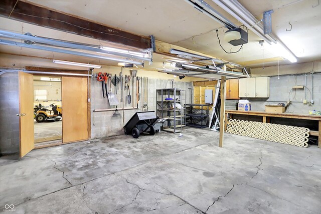 6644 Mcfarland Rd, Indianapolis, IN 46227 - garage featuring a garage door opener, concrete block wall, and a workshop area