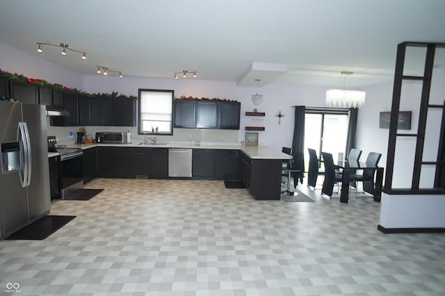 1673 W Integrity St, Greensburg, IN 47240 - kitchen with appliances with stainless steel finishes, a peninsula, light countertops, a chandelier, and under cabinet range hood
