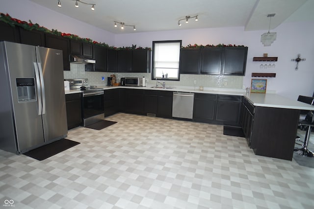 1673 W Integrity St, Greensburg, IN 47240 - kitchen with stainless steel appliances, a peninsula, a sink, under cabinet range hood, and light countertops