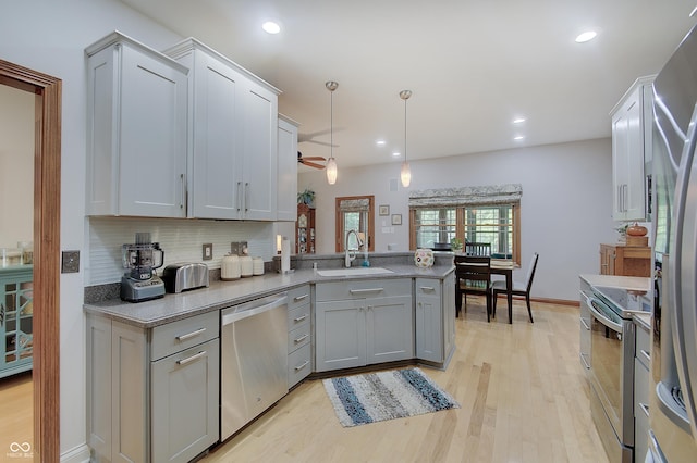 214 W Stoney Trl, Greenfield, IN 46140 - kitchen featuring stainless steel appliances, backsplash, light wood-type flooring, a peninsula, and light countertops