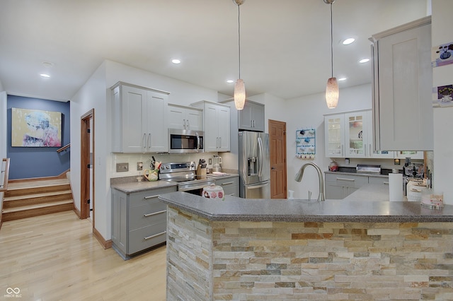 214 W Stoney Trl, Greenfield, IN 46140 - kitchen with stainless steel appliances, a peninsula, recessed lighting, light wood finished floors, and glass insert cabinets