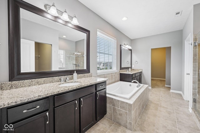10806 Solis Cir, Fishers, IN 46038 - bathroom featuring tiled shower, two vanities, a garden tub, and tile patterned floors