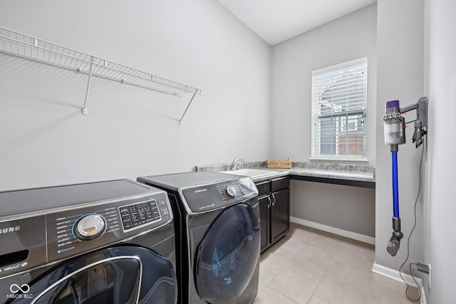 10806 Solis Cir, Fishers, IN 46038 - laundry area featuring cabinet space, washing machine and dryer, and light tile patterned floors