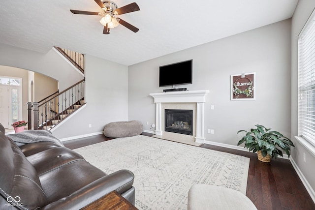 10806 Solis Cir, Fishers, IN 46038 - living room with wood finished floors, ceiling fan, a fireplace with flush hearth, stairs, and arched walkways