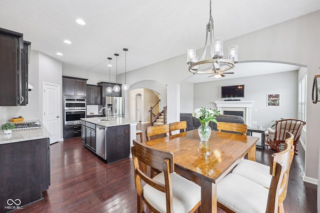 10806 Solis Cir, Fishers, IN 46038 - dining room featuring arched walkways, dark wood finished floors, a fireplace, recessed lighting, and ceiling fan