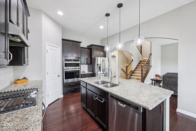 10806 Solis Cir, Fishers, IN 46038 - kitchen featuring appliances with stainless steel finishes, arched walkways, light stone countertops, dark wood-style flooring, and recessed lighting