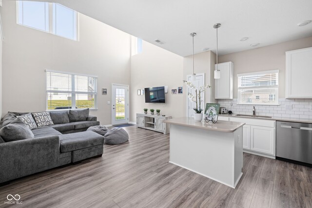 2892 Maricopa Blvd, Whitestown, IN 46075 - kitchen featuring dishwasher, open floor plan, light wood-style floors, white cabinets, and a high ceiling