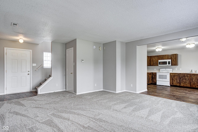 8030 Cork Bend Ln, Indianapolis, IN 46239 - unfurnished living room featuring dark colored carpet, a textured ceiling, a sink, baseboards, and stairway