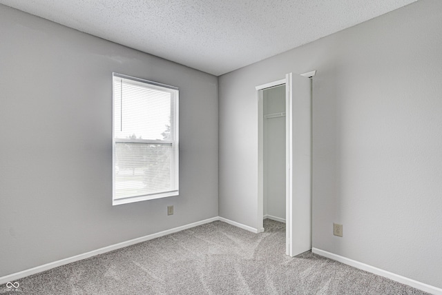 8030 Cork Bend Ln, Indianapolis, IN 46239 - unfurnished bedroom with multiple windows, carpet, a textured ceiling, baseboards, and a closet