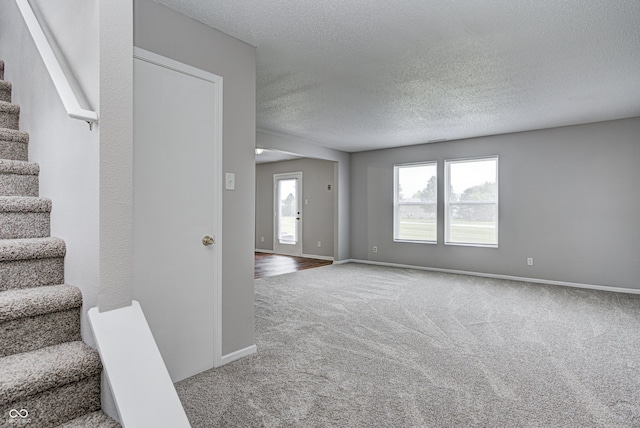 8030 Cork Bend Ln, Indianapolis, IN 46239 - unfurnished living room with stairway, carpet flooring, a textured ceiling, and baseboards
