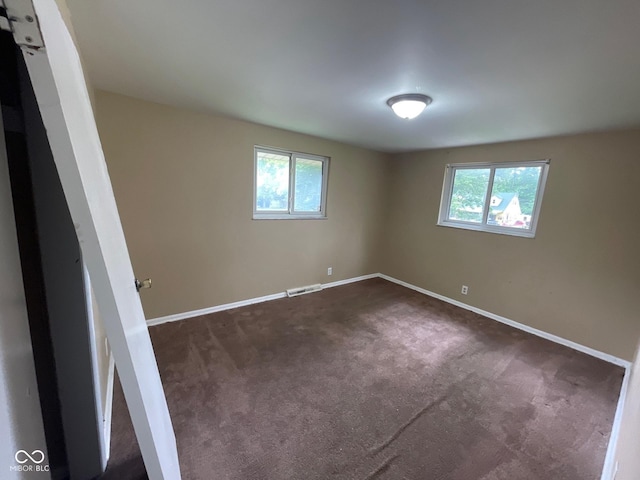 1749 N Graham Ave, Indianapolis, IN 46218 - empty room with healthy amount of natural light and dark colored carpet