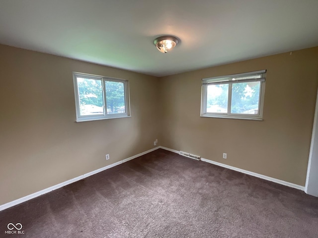 1749 N Graham Ave, Indianapolis, IN 46218 - spare room with healthy amount of natural light and dark colored carpet