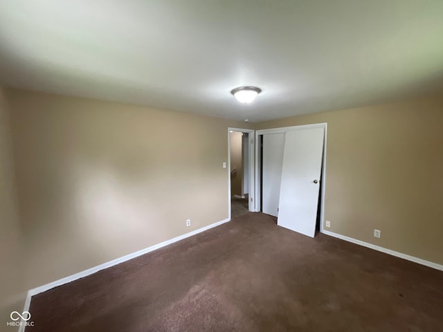 1749 N Graham Ave, Indianapolis, IN 46218 - unfurnished bedroom featuring a closet and dark carpet