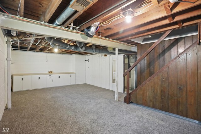 808 N Layman Ave, Indianapolis, IN 46219 - unfinished basement with carpet flooring, stairway, and wooden walls
