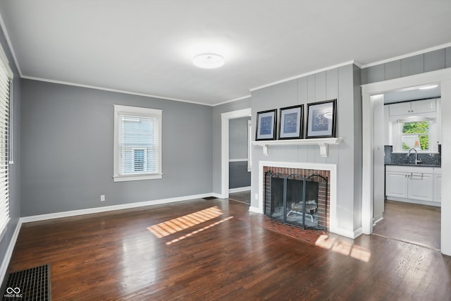 808 N Layman Ave, Indianapolis, IN 46219 - unfurnished living room featuring wood finished floors, crown molding, and a fireplace