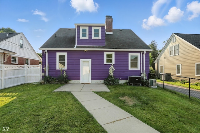 808 N Layman Ave, Indianapolis, IN 46219 - rear view of house with a fenced backyard, a chimney, and roof with shingles