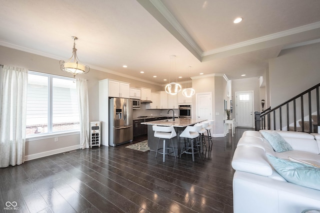 14982 Dawnhaven Dr, Westfield, IN 46074 - kitchen featuring appliances with stainless steel finishes, light stone countertops, a kitchen bar, an island with sink, and white cabinetry