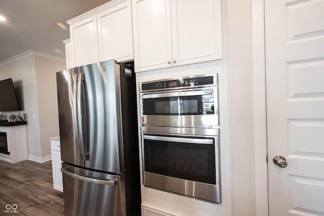 9671 Holborn Ave, Mccordsville, IN 46055 - kitchen featuring appliances with stainless steel finishes, white cabinets, dark wood-style floors, crown molding, and light stone counters
